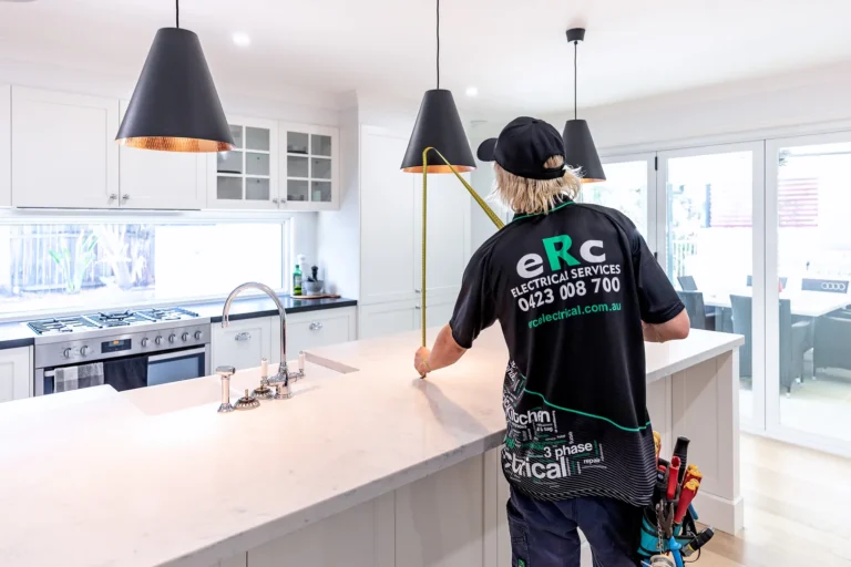 Electrician measuring kitchen island lighting installation.