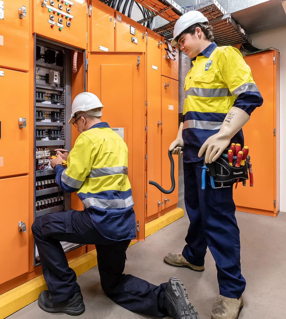 Electricians working on an electrical panel.
